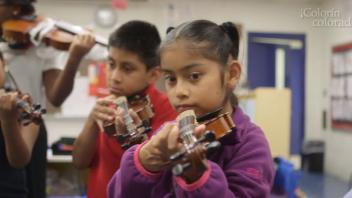 Young Latino/a children at a community school playing the violin