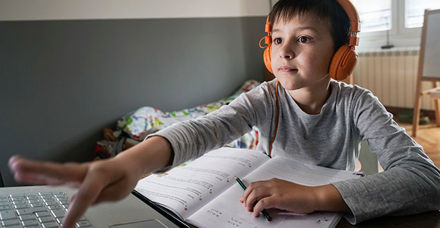 Elementary student working on schoolwork on computer at home