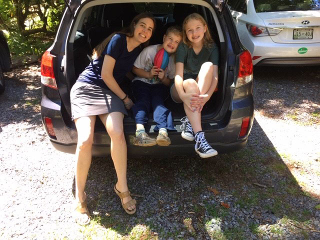 Young family with packed car ready to head out West on a summer road trip