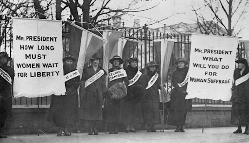 Suffragists out in the streets with banners