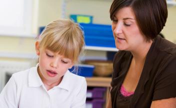 elementary teacher working one-on-one with female student