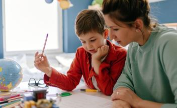 Mother helping elementary son with homework