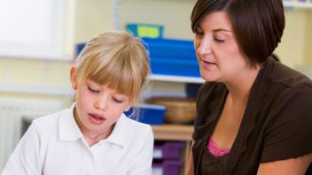 elementary teacher working one-on-one with female student