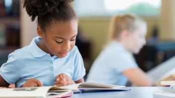 Elementary student in class practicing reading