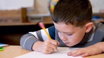 Elementary student concentrating on his writing in class