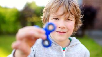 Young boy holding spinner fidget