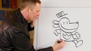 Dav Pilkey drawing Dog Man on flip chart