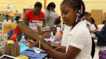 Young girl making a robot out of cardboard