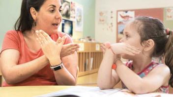Teacher reading to deaf child using ASL