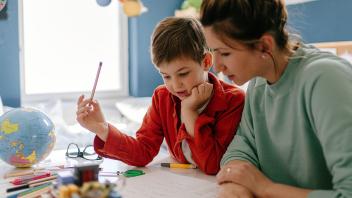 Mother helping elementary son with homework