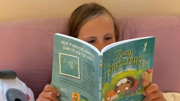 First grader reading a beginning chapter book at home