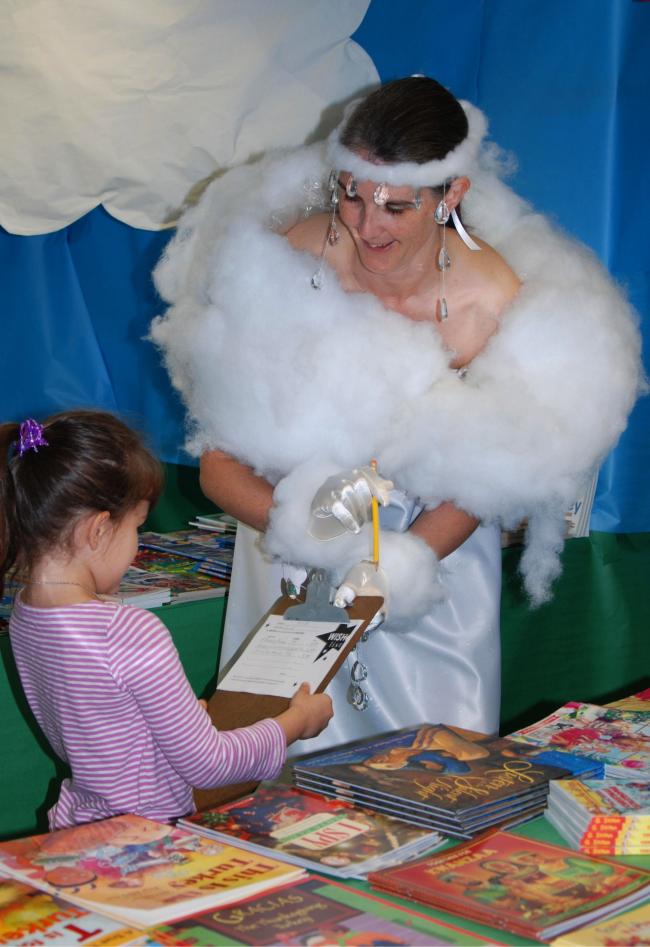 Woman dressed as cumulus cloud sharing books with young reader